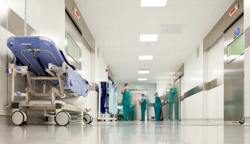 Hospital corridor with stretcher and medical staff.