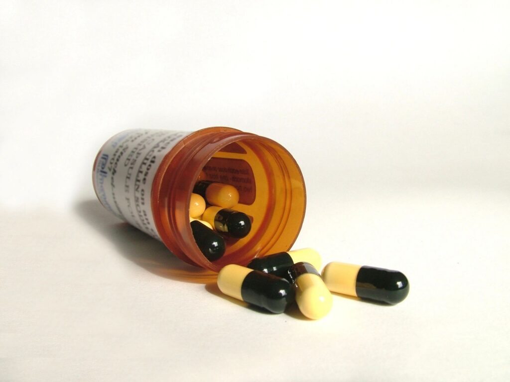 Prescription bottle with yellow-black capsules.