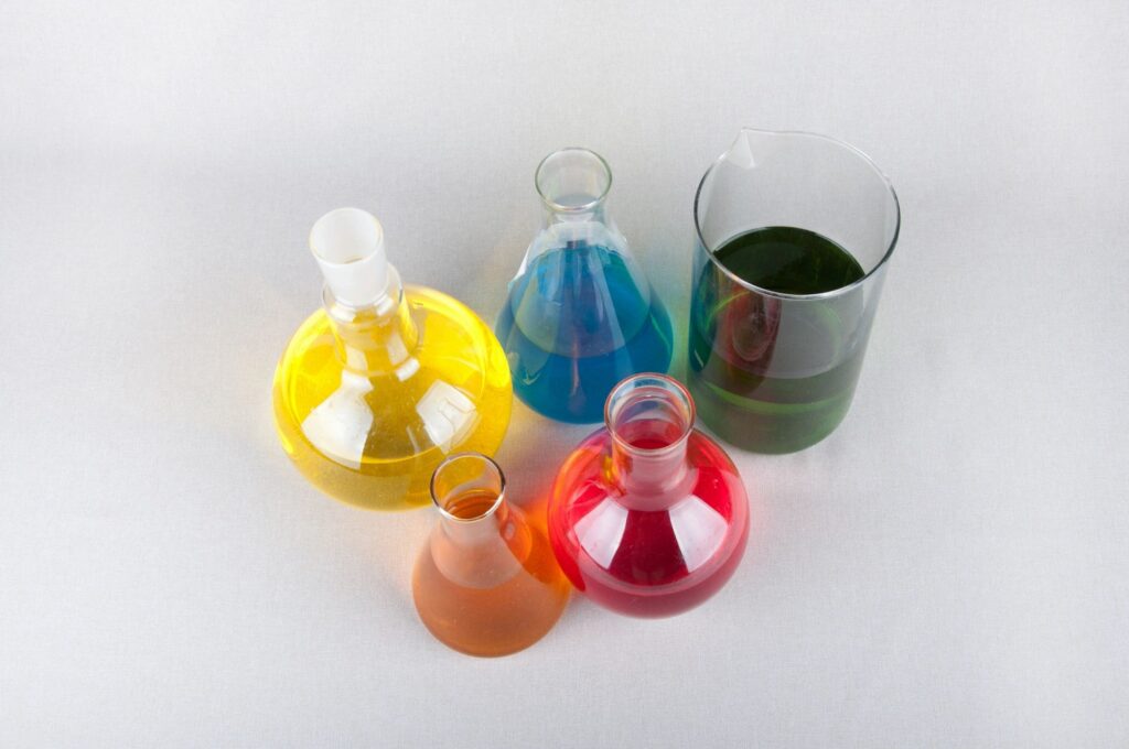 Colorful chemical solutions in laboratory glassware.