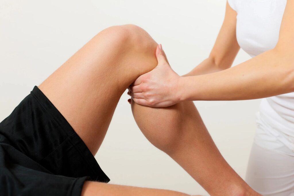 Physical therapist massaging a patient's leg.