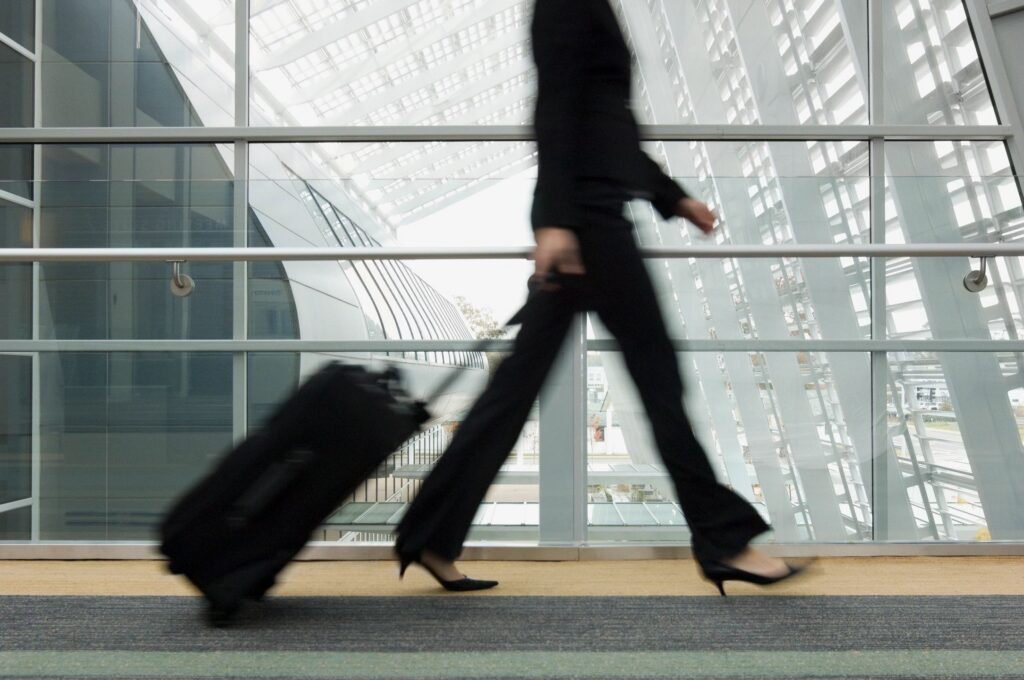 Person walking with suitcase in modern airport.