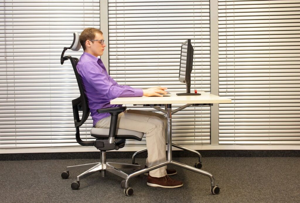 Man sitting at desk using computer.