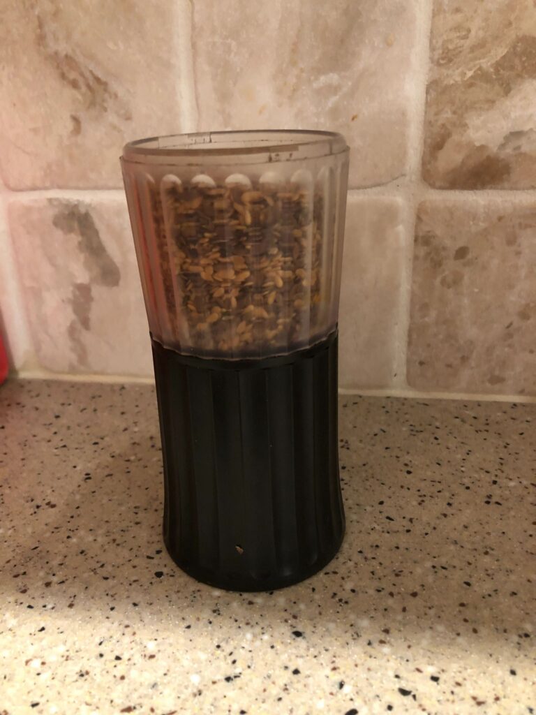 Black and clear spice grinder on countertop.