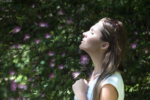 Woman enjoying nature in sunlit garden.
