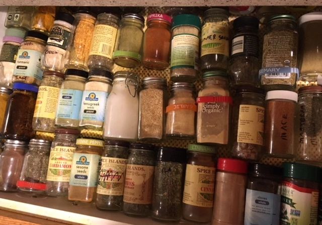 Assorted spice jars organized in a drawer.