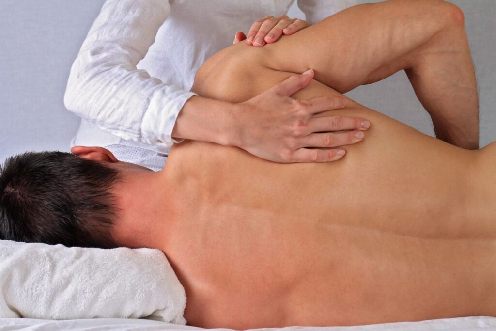 Person receiving a back massage on table.