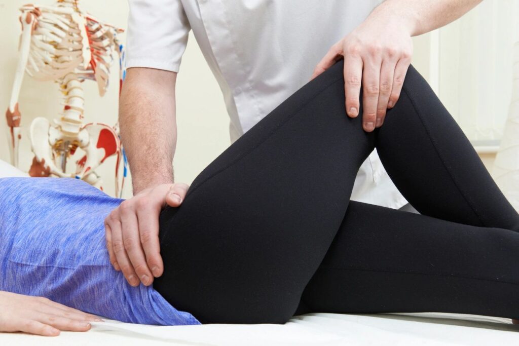 Physical therapy session with patient on table.