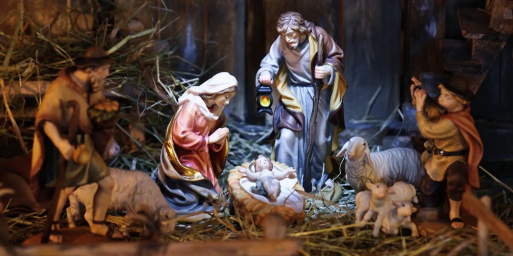 Nativity scene with a baby Jesus in the manger surrounded by a group of people and animals