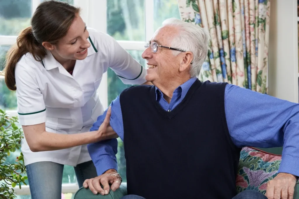 Man sitting on a couch with a nurse standing beside him