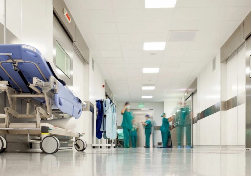 Hospital corridor with stretcher and medical staff.