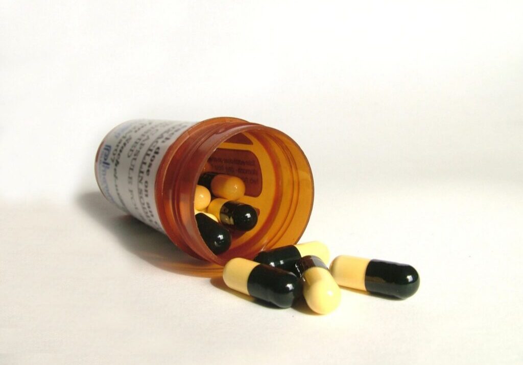 Prescription bottle with yellow-black capsules.