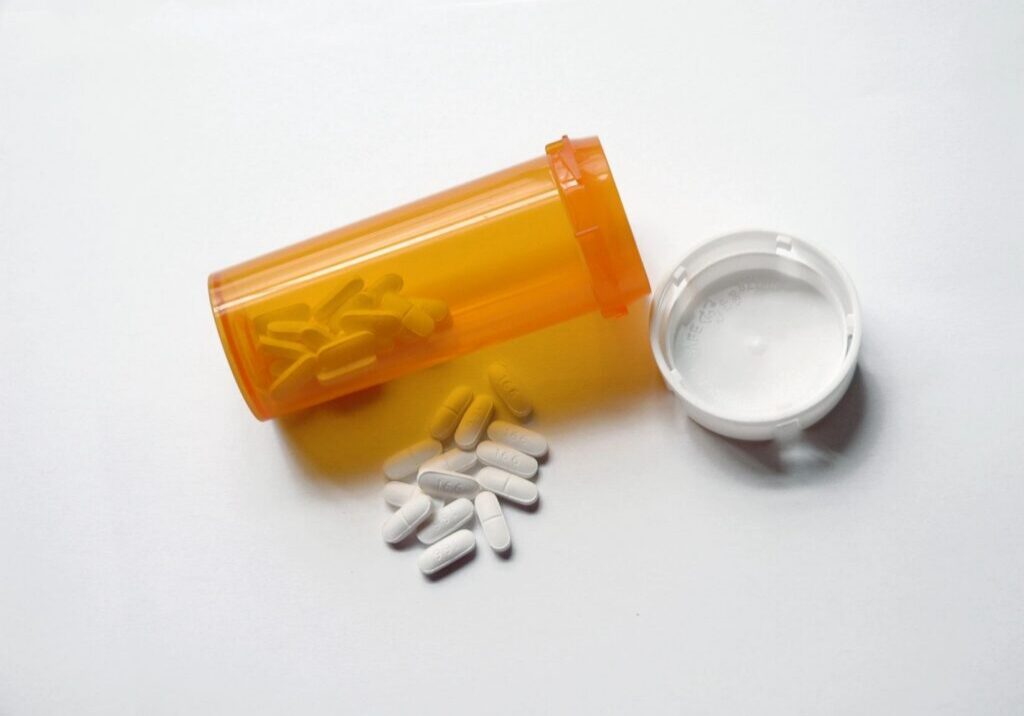 Orange pill bottle with white tablets.