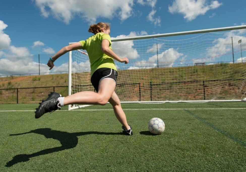 Soccer player kicking ball towards goal.