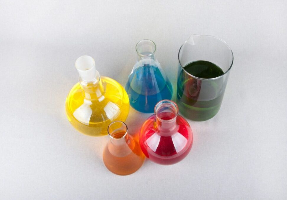 Colorful chemical solutions in laboratory glassware.