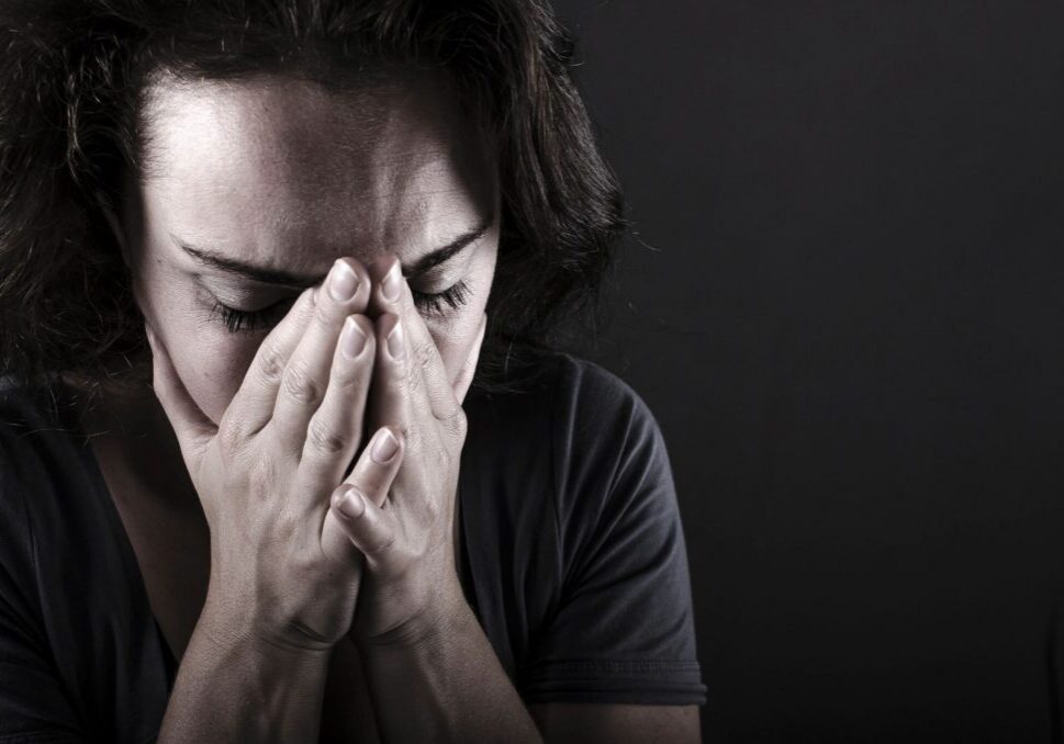 Person covering face with hands, appearing distressed.
