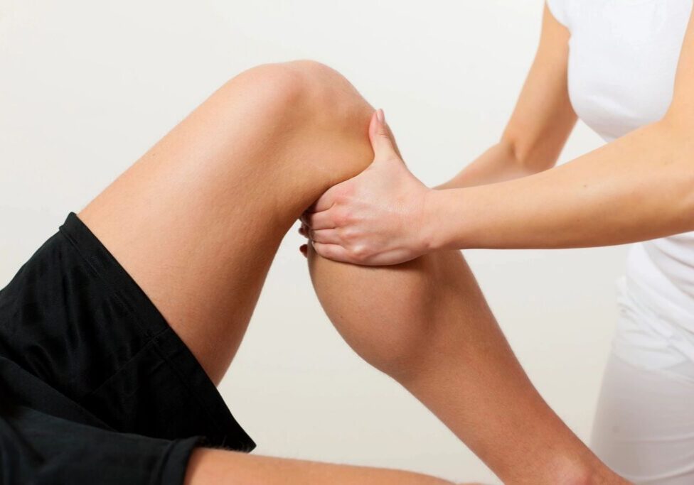 Physical therapist massaging a patient's leg.