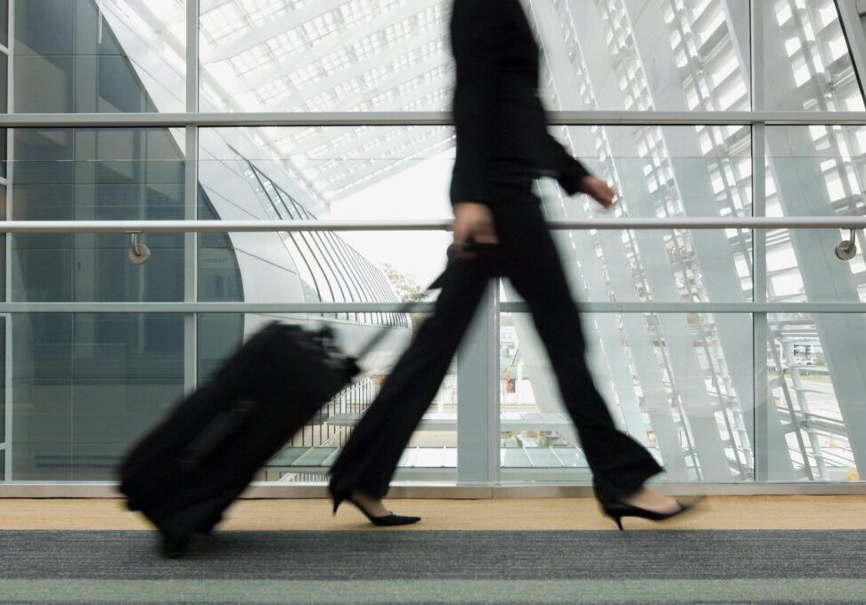 Person walking with suitcase in modern airport.