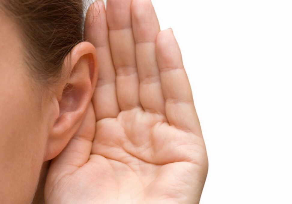 Person cupping ear, listening intently.