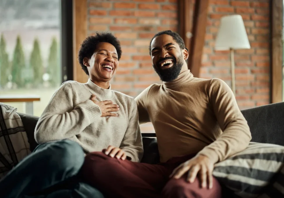Man and woman sitting on a couch, at each other