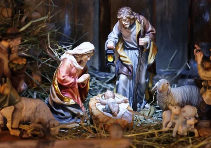 Nativity scene with a baby Jesus in the manger surrounded by a group of people and animals