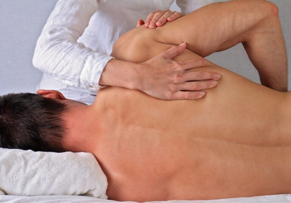 Person receiving a back massage on table.